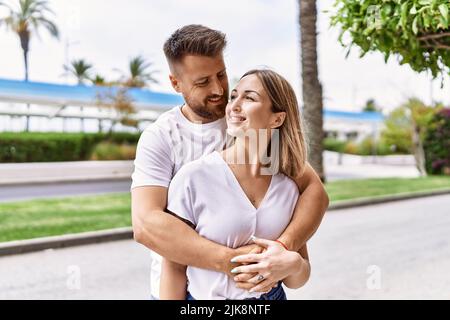 Jeune couple caucasien de petit ami et de petite amie ayant l'amusement à l'extérieur sur un jour ensoleillé de l'onu embrassant dans l'amour Banque D'Images