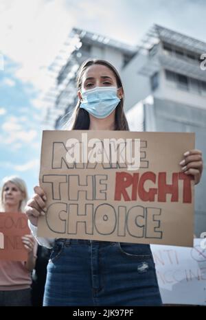 Prenez la bonne décision pour vous-même. Une jeune femme protestant lors d'une marche contre le vaccin contre le covid. Banque D'Images