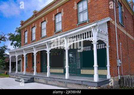 Ancien bâtiment en brique avec porche avant pleine largeur, à l'origine un magasin général rural de la 1890s Banque D'Images