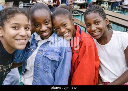 Miami Florida,Frederick Douglass Elementary School,communauté de quartier à faible revenu,Black African Student filles Friends cafétéria tables de salle à manger Banque D'Images