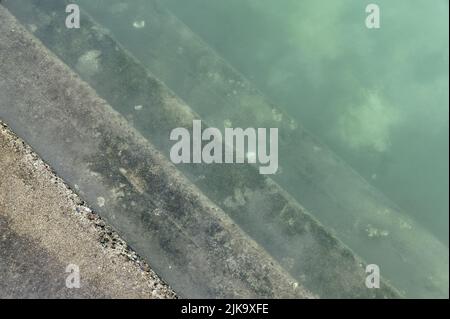 Les marches s'enfoncent dans une piscine d'eau salée, l'eau est légèrement trouble Banque D'Images