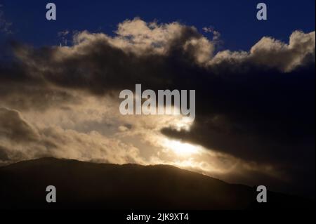 Les collines sont jetées dans l'ombre par des nuages se déplaçant à travers le ciel et bloquant le soleil. Banque D'Images