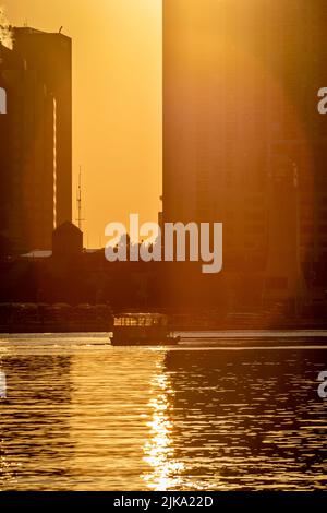 Bateau-taxi transportant des touristes du port de Toronto à l'île de Toronto, éclairé par le soleil levant Banque D'Images