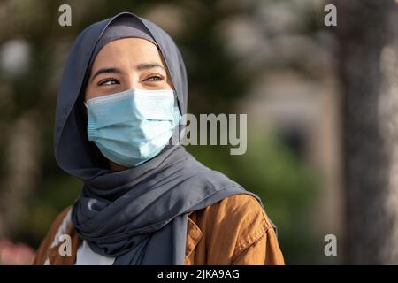 Femme musulmane portant un masque facial de protection à l'extérieur Banque D'Images