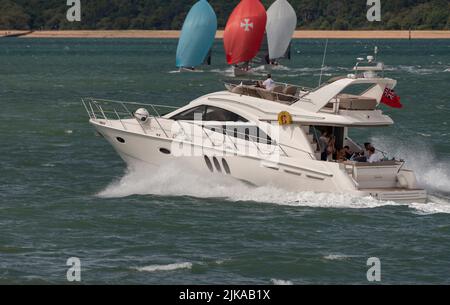 The Solent, sud de l'Angleterre, Royaume-Uni. 2022. Bateau à moteur de luxe traversant le chemin des yachts en compétition dans la semaine de Cowes course au large de la côte du Hampshire près de Calsh Banque D'Images