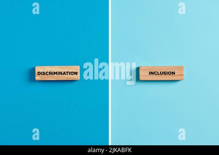 Les mots discrimination et inclusion sur les blocs de bois. Dilemme ou choix entre le concept de discrimination ou d'inclusion. Banque D'Images