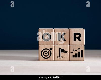 Concept des objectifs et des résultats clés d'OKR sur des cubes en bois. Objectif d'entreprise, réalisation de la croissance et concept de performance. Banque D'Images