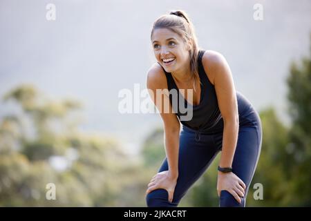 Cardio juste vous fait vous sentir bien. Une jeune femme sportive attrapant son souffle tout en faisant de l'exercice à l'extérieur. Banque D'Images