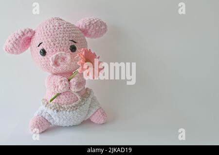 Animal en crochet doux tenant la fleur Banque D'Images