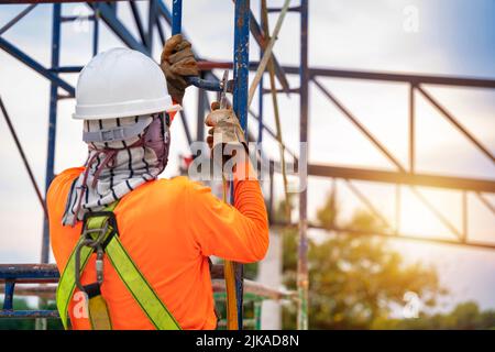 Les travailleurs de la construction en gros plan utilisent des équipements de sécurité pour empêcher les chutes de hauteur ou un dispositif antichute pour les travailleurs équipés de crochets pour le corps de sécurité h Banque D'Images