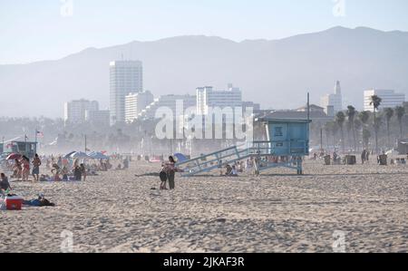 Los Angeles, 12 juillet 2022 : les gens profitent du soleil de l'après-midi à Venice Beach, Los Angeles, avec des collines brumeuses en arrière-plan Banque D'Images