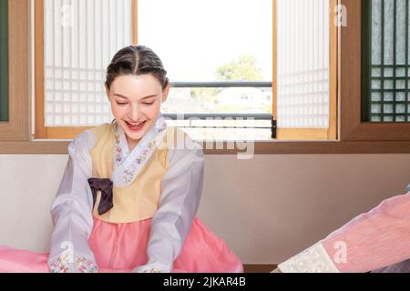 Des filles coréennes et caucasiennes portant Hanbok jouant à Yut, jeu de société traditionnel coréen Banque D'Images