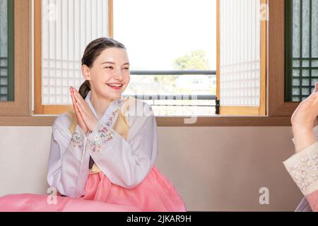 Des filles coréennes et caucasiennes portant Hanbok jouant à Yut, jeu de société traditionnel coréen Banque D'Images