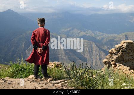 Dagestan, Russie - 21 juillet, 2022: L'homme local dans la tradition nationale habille contre la montagne du Caucase et regardant la distance dans le village de Go Banque D'Images