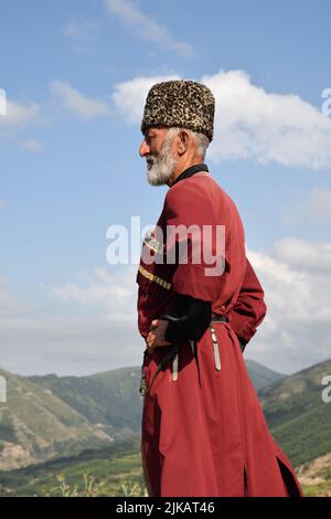 Dagestan, Russie - 21 juillet, 2022: Homme local dans la tradition nationale robe debout en profil contre les montagnes caucasiennes dans le village de Goor Banque D'Images