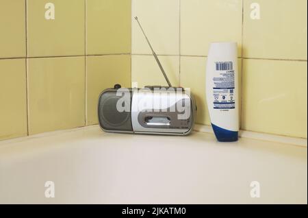 radio portable et bouteille de shampooing dans la salle de bains Banque D'Images