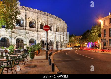 Nuit à Nîmes, France avec la belle arène romaine dominant le BD des Arènes. Banque D'Images