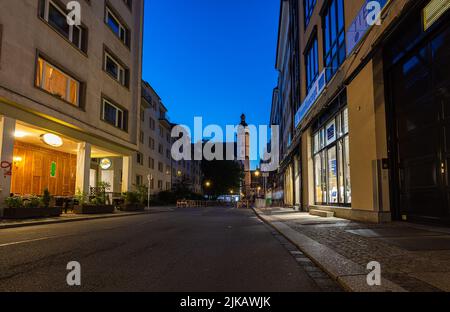 Leipzig, Allemagne - 02 juillet 2022 : église Saint-Thomas ou Thomaskirche, vue le long de la Burgstrasse à l'aube d'une nuit d'été. Bâtiments éclairés par la vieille lante Banque D'Images