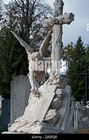 Sculpture tombeau d'un ange mettant une fleur sur une pierre tombale au cimetière de Lychakiv à Lviv, Ukraine Banque D'Images