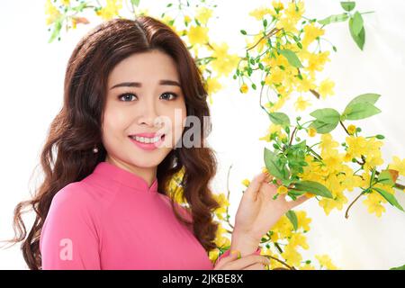 Portrait de la belle jeune femme asiatique debout à côté de l'abricot en fleur Banque D'Images