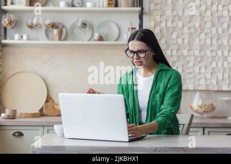 travail à distance, technologie et concept de personnes - jeune femme fatiguée ou stressée avec ordinateur portable travaillant au bureau à domicile Banque D'Images