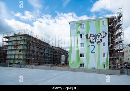 deux immeubles modernes, dont l'un est doté d'un échafaudage en façade, artistiquement conçu avec un motif de formes polygonales, symbolisant l'orme floral Banque D'Images