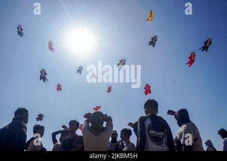 Denpasar, Indonésie. 31st juillet 2022. Les gens se rassemblent pour assister au festival de cerf-volant. Des milliers de personnes affluent à Mertasari Beach à Sanur pour un festival de cerf-volant pendant la saison de cerf-volant de Bali, qui s'étend de mai à septembre chaque année, entre la saison sèche. Le festival est le meilleur moment de l'année pour visiter Bali. Les couleurs rouge, blanc, noir et jaune-or représentent les incarnations des divinités hindoues balinaises. Crédit : SOPA Images Limited/Alamy Live News Banque D'Images