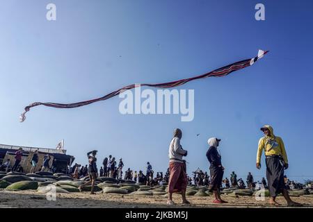 Denpasar, Indonésie. 31st juillet 2022. Les gens se rassemblent pour assister au festival de cerf-volant. Des milliers de personnes affluent à Mertasari Beach à Sanur pour un festival de cerf-volant pendant la saison de cerf-volant de Bali, qui s'étend de mai à septembre chaque année, entre la saison sèche. Le festival est le meilleur moment de l'année pour visiter Bali. Les couleurs rouge, blanc, noir et jaune-or représentent les incarnations des divinités hindoues balinaises. Crédit : SOPA Images Limited/Alamy Live News Banque D'Images