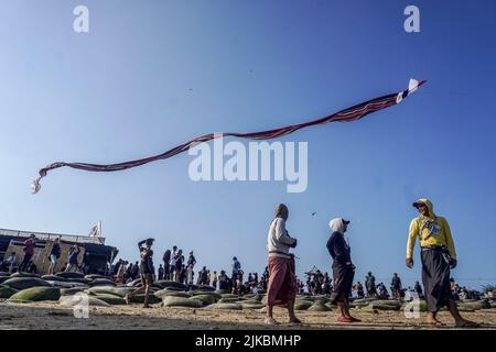 Denpasar, Indonésie. 31st juillet 2022. Les gens se rassemblent pour assister au festival de cerf-volant. Des milliers de personnes affluent à Mertasari Beach à Sanur pour un festival de cerf-volant pendant la saison de cerf-volant de Bali, qui s'étend de mai à septembre chaque année, entre la saison sèche. Le festival est le meilleur moment de l'année pour visiter Bali. Les couleurs rouge, blanc, noir et jaune-or représentent les incarnations des divinités hindoues balinaises. (Photo de Dicky Bisinglasi/SOPA Images/Sipa USA) crédit: SIPA USA/Alay Live News Banque D'Images