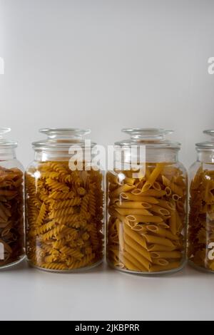 Différents types de pâtes italiennes debout les unes à côté des autres dans des pots en verre Banque D'Images