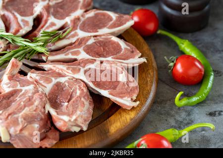 Côtelettes d'agneau. Côtelette sur fond sombre. Boucher les produits. Gros plan Banque D'Images