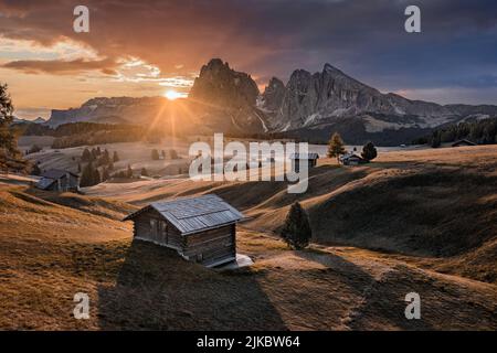 Alpe di Siusi, Italie - magnifique lever de soleil d'automne avec chalets en bois à Seiser Alm, un plateau des Dolomites dans la province du Tyrol du Sud dans le massif des Dolomites Banque D'Images