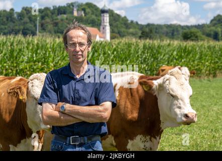 01 août 2022, Bavière, Pähl: L'agriculteur Georg Schweiger est debout sur un pâturage dans le village de Pähl, dans le quartier bavarois supérieur de Weilheim-Schongau. En raison de la forte densité présumée de bouées de vache sur la route, un résident local s'était déjà plaint auprès des autorités. Maintenant, l'agriculteur doit payer une amende de 100 euros plus 30 euros de frais. Photo: Peter Kneffel/dpa Banque D'Images