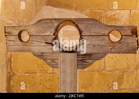 Vieux stocks de bois médiévaux pour punir les criminels sur le fond d'un mur de pierre Banque D'Images