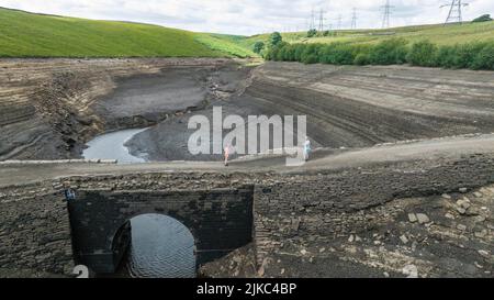 Ripponden, Royaume-Uni. 01st août 2022. Un homme et sa fille sur un vieux pont qui est normalement submergé sous l'eau est complètement exposé car l'eau dans le réservoir est gravement épuisée à Baitings Reservoir près de Ripponden West Yorkshire, Royaume-Uni le 01/08/2022 à Ripponden, Royaume-Uni le 8/1/2022. (Photo de Mark Cosgrove/News Images/Sipa USA) crédit: SIPA USA/Alay Live News Banque D'Images