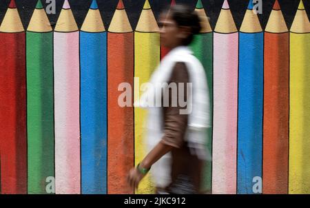 Mumbai, Maharashtra, Inde. 1st août 2022. Une femme passe devant un mur graffiti d'une école à Mumbai, Inde, 01 août 2022. (Credit image: © Indranil Aditya/ZUMA Press Wire) Banque D'Images