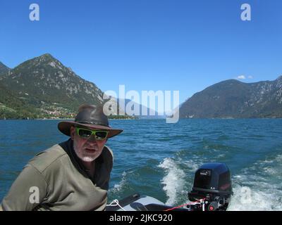 homme conduisant un bateau sur un lac dans les montagnes Banque D'Images