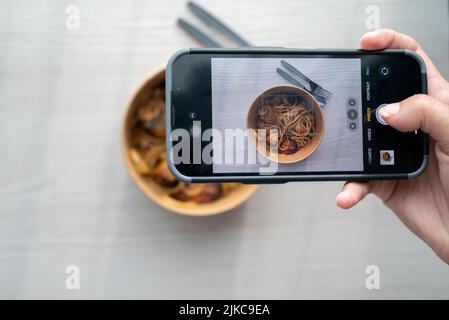 Shoot First Eat later concept, le tournage thaï épice herbe pâtes vue. Médias sociaux, partage de repas. Banque D'Images