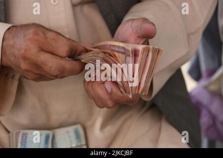 Kaboul, Afghanistan. 1st août 2022. Un homme compte de l'argent dans un marché de change à Kaboul, en Afghanistan, le 1 août 2022. L'Afghanistan a reçu un nouveau lot de 40 millions de dollars américains d'aide humanitaire en espèces et a été déposé à l'une des banques commerciales du pays, a déclaré la banque centrale dans une déclaration lundi. Credit: Saifurahman Safi/Xinhua/Alamy Live News Banque D'Images