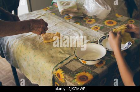 Les mains des filles et de la grand-mère prennent des crêpes pour manger Banque D'Images