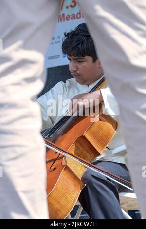Un jeune prodige et membre de l'ensemble de musique chinoise de New York joue le violoncelle au Hong Kong Dragon Boat Festival à Queens, New York. Banque D'Images