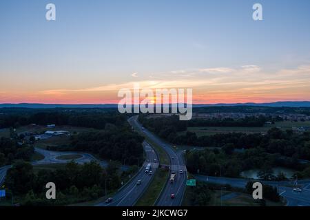 Le soleil se couche derrière la montagne Catoctin alors que les voitures et les camions parcourent l'Interstate 270 à Urbana, dans le comté de Frederick, dans le Maryland. Banque D'Images