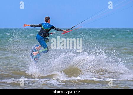 Kitesurf montrant kiteboarder / kitesurfer sur le twintip jumping sur la mer du Nord par une journée venteuse Banque D'Images