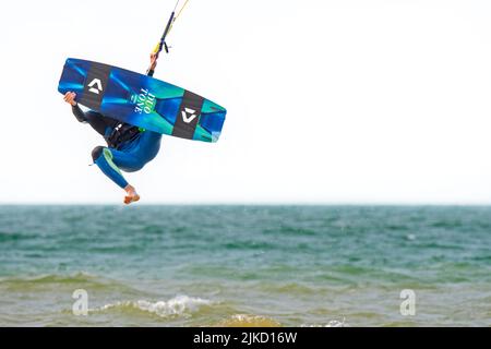 Kitesurf montrant kiteboarder / kitesurfer sur le twintip jumping sur la mer du Nord par une journée venteuse Banque D'Images