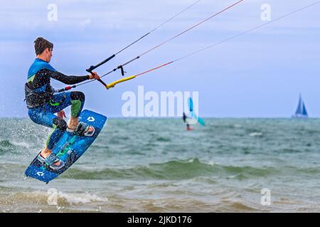 Kitesurf montrant kiteboarder / kitesurfer sur le twintip jumping sur la mer du Nord par une journée venteuse Banque D'Images