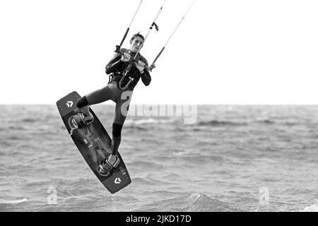 Kitesurf montrant kiteboarder / kitesurfer sur le twintip jumping sur la mer du Nord par une journée venteuse Banque D'Images