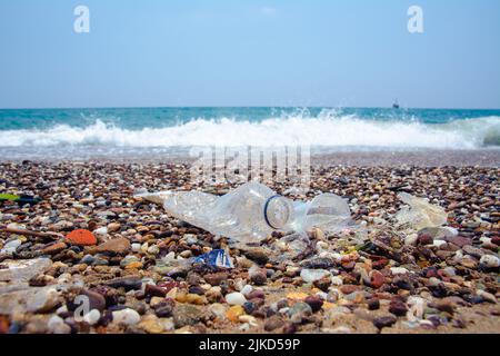 Déchets sur la plage. Une poubelle fabriquée par l'homme dans la mer : bouteilles en plastique, verres et autres plastiques. La photo montre les problèmes de l'environnement dus t Banque D'Images