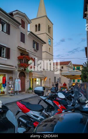 Vue sur l'église Saint-Georges et les magasins au crépuscule dans le village de Lovran, Lovran, baie de Kvarner, Istrie orientale, Croatie, Europe Banque D'Images