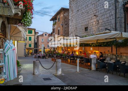 Vue sur les cafés, restaurants et magasins au crépuscule dans le village de Lovran, Lovran, baie de Kvarner, Istrie orientale, Croatie, Europe Banque D'Images