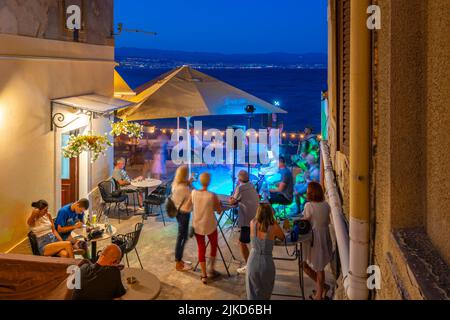 Vue sur le café et les divertissements dans le port au crépuscule, Lovran village, Lovran, Kvarner Bay, Istrie orientale, Croatie, Europe Banque D'Images